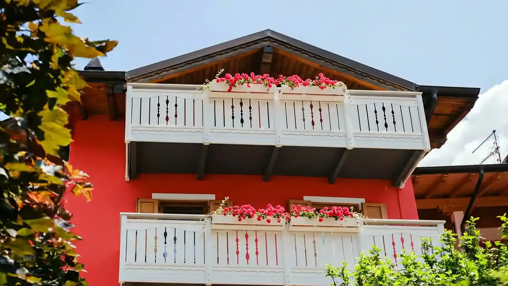 The red facade of Residenza Garibaldi with its flowered balconies
