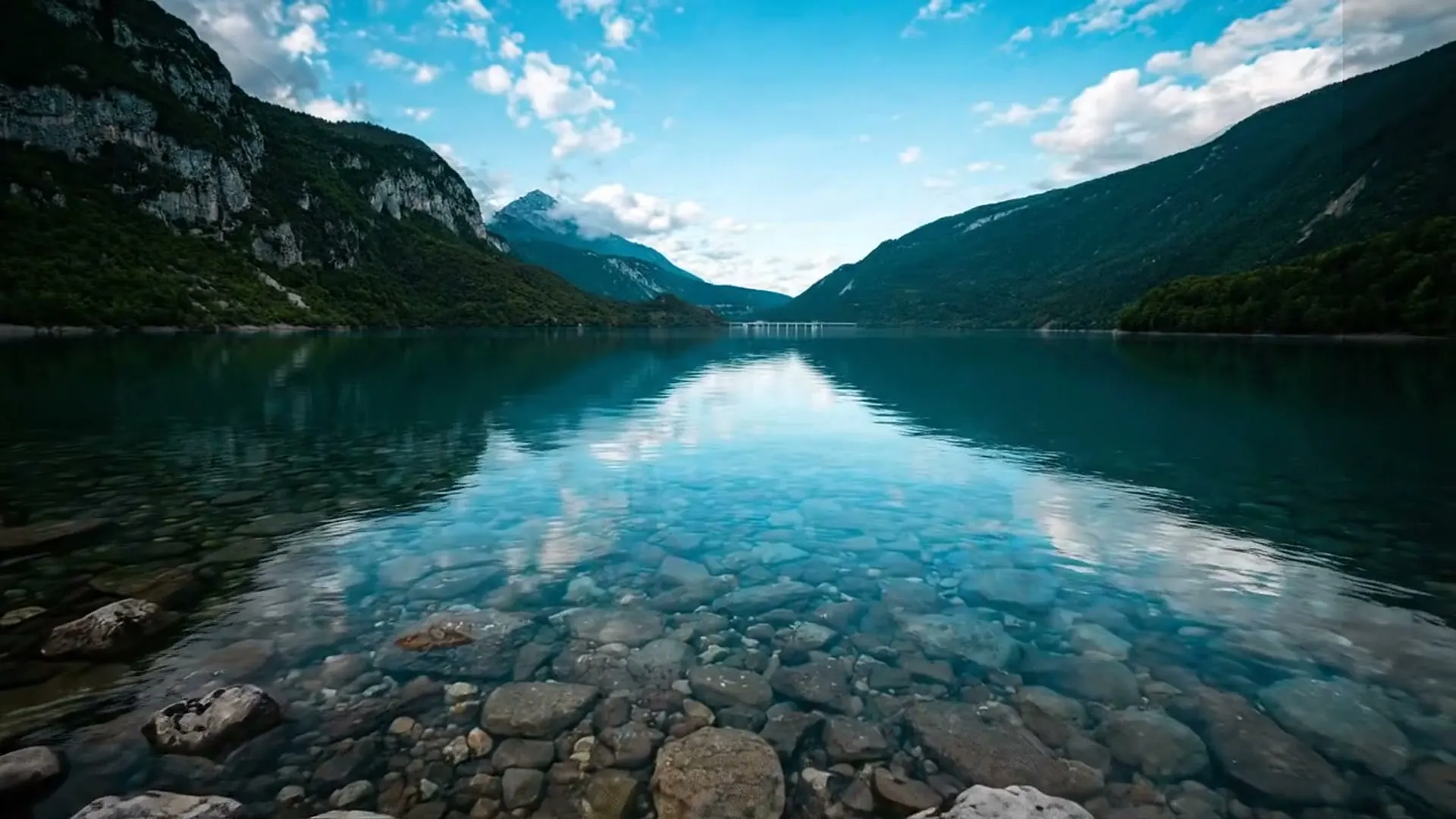 The clear water of Lake Molveno, with the mountains reflected in it