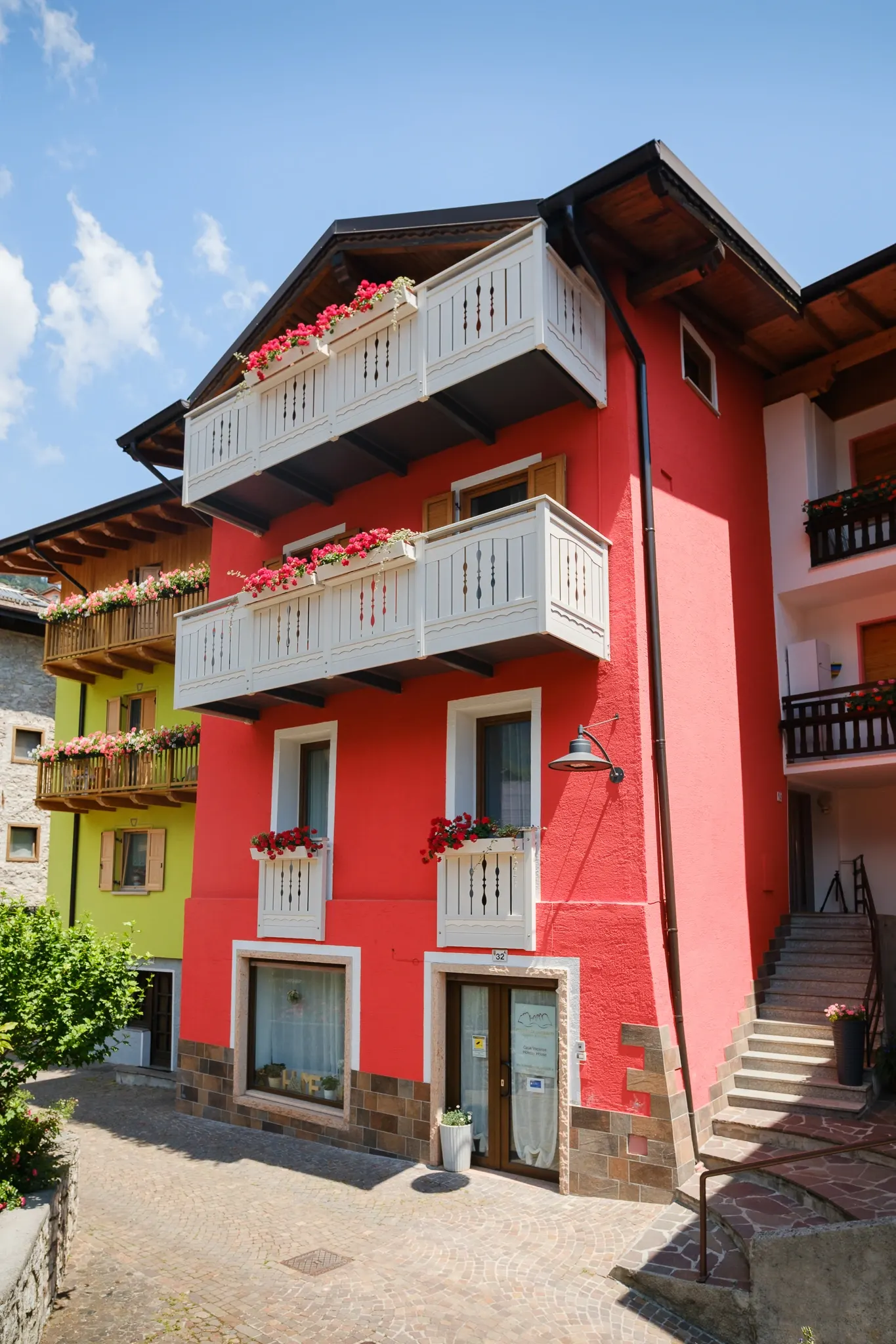 La facciata rossa della Residenza Garibaldi con i balconi in legno