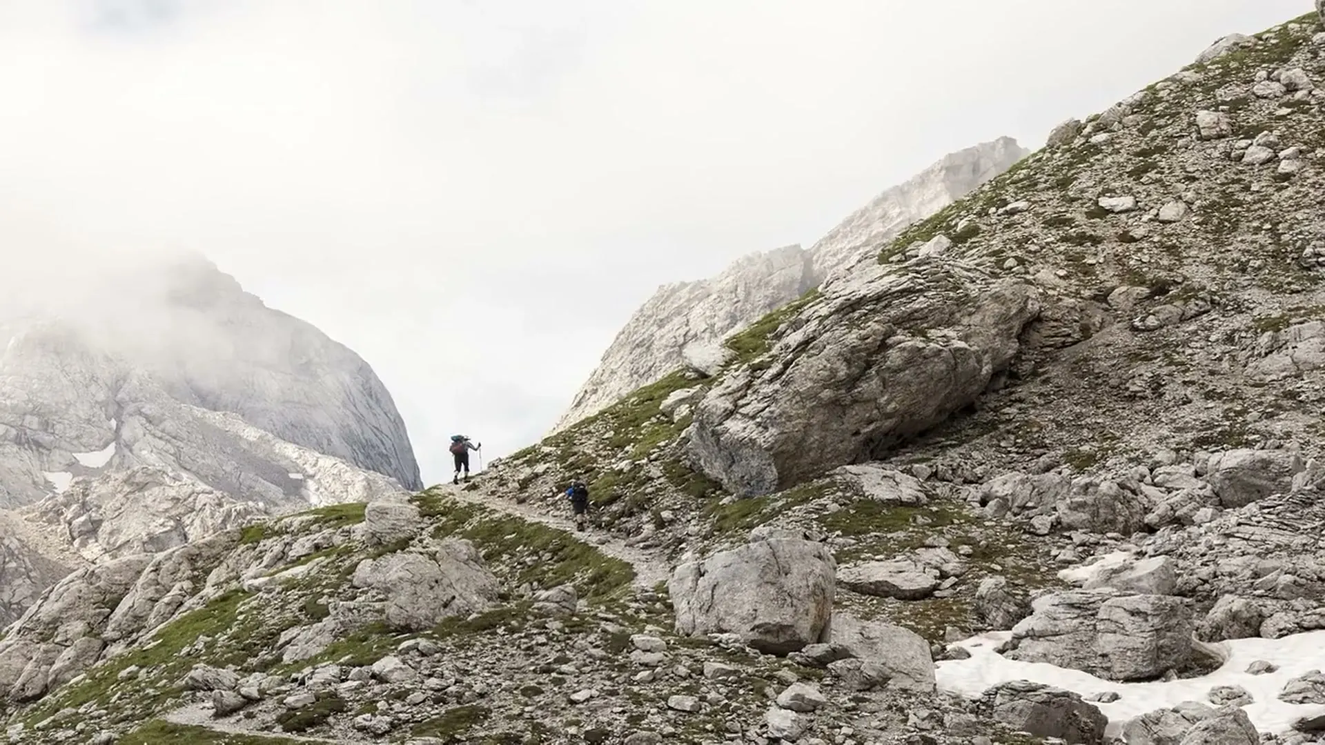 Three hikers in front of the Agostini hut in the Brenta Dolomites